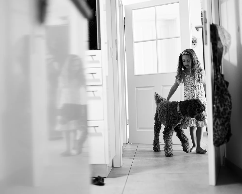 Lena-Heinemann-Familienfotos-Stuttgart-Mannheim-Wuerzburg-10 Lena Heinemann Familienfotos in Stuttgart, Mannheim und Würzburg, Bild zeigt Mädchen mit Familienhund im Flur