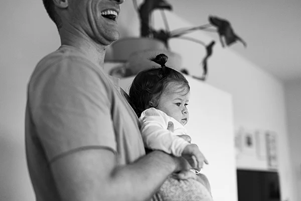 Lena-Heinemann-Familienfotos-Stuttgart-Mannheim-Wuerzburg-14 Lena Heinemann Familienfotos in Stuttgart, Mannheim und Würzburg, Bild zeigt Papa mit Baby vor der Brust