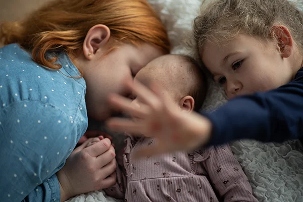 Lena Heinemann Familienfotos in Stuttgart, Mannheim und Würzburg, 3 Geschwister, die zusammen auf dem Bett liegen