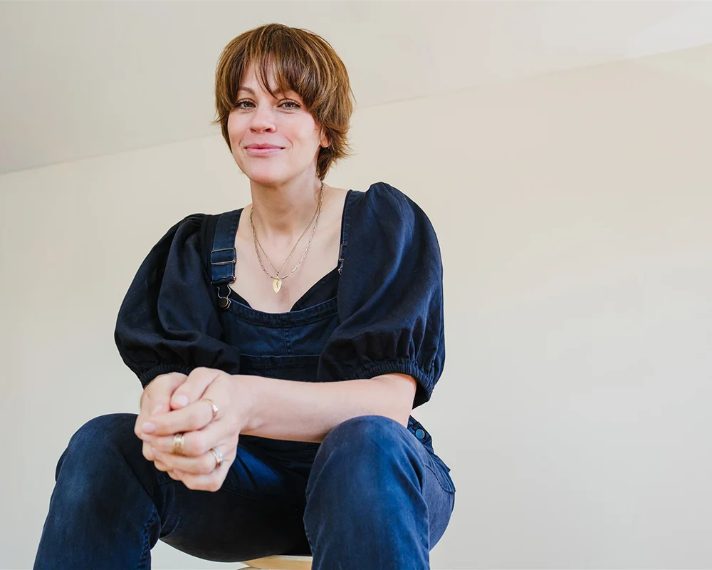 Lena Heinemann Fotografin im blauen Shirt und sitzend