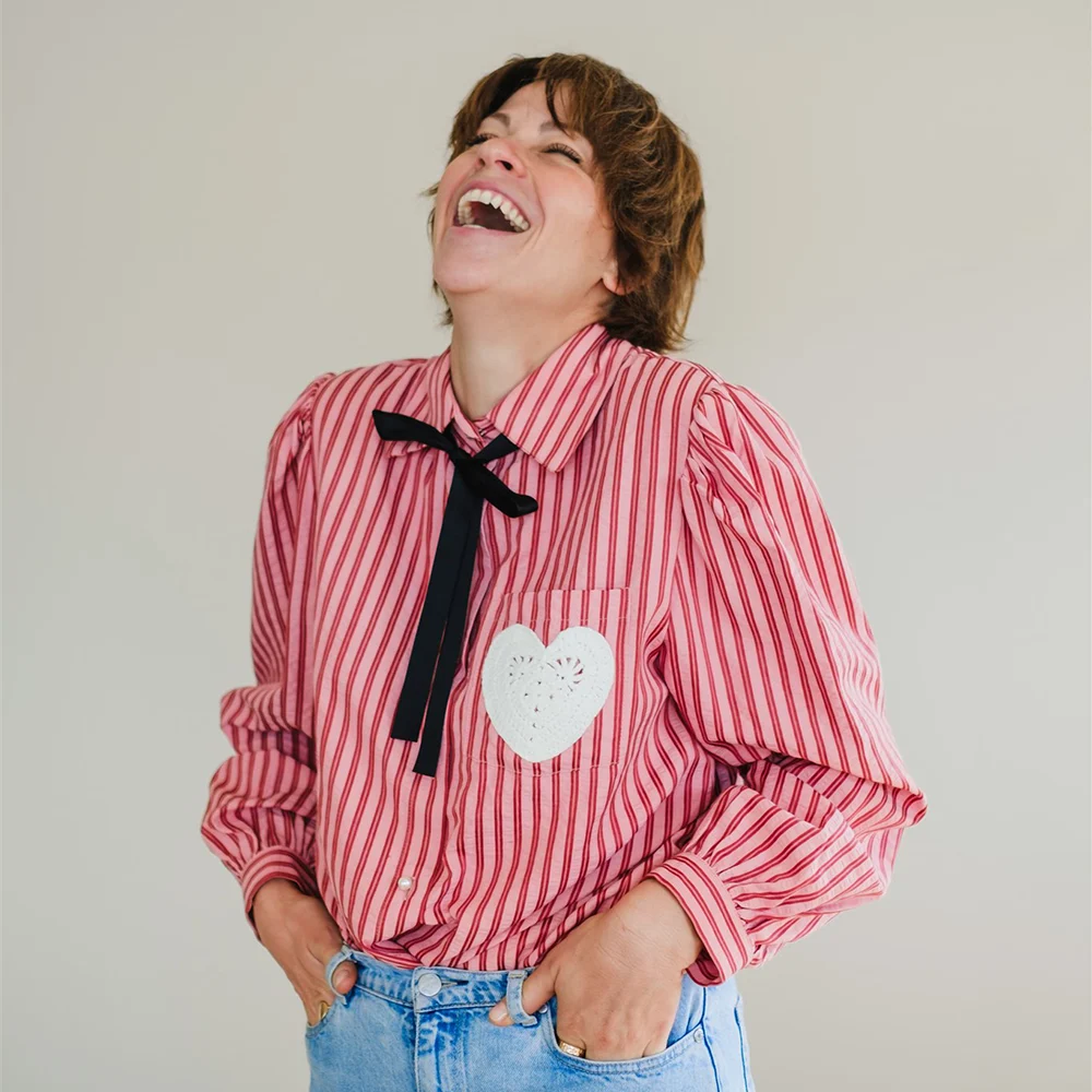 Lena Heinemann Fotografin, im Bild nur steht sie lachend mit geschlossenen Augen da