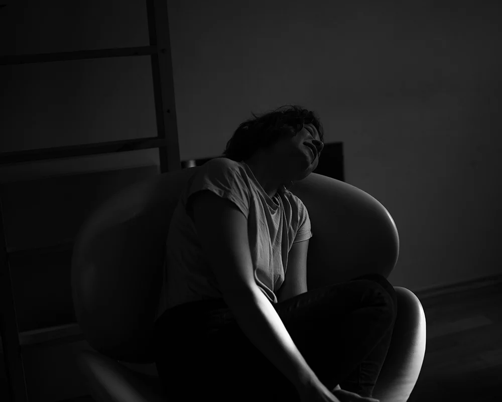 Lena Heinemann Porträtfotografie Stuttgart, schwarzweißes Bild einer Frau in einem Sessel