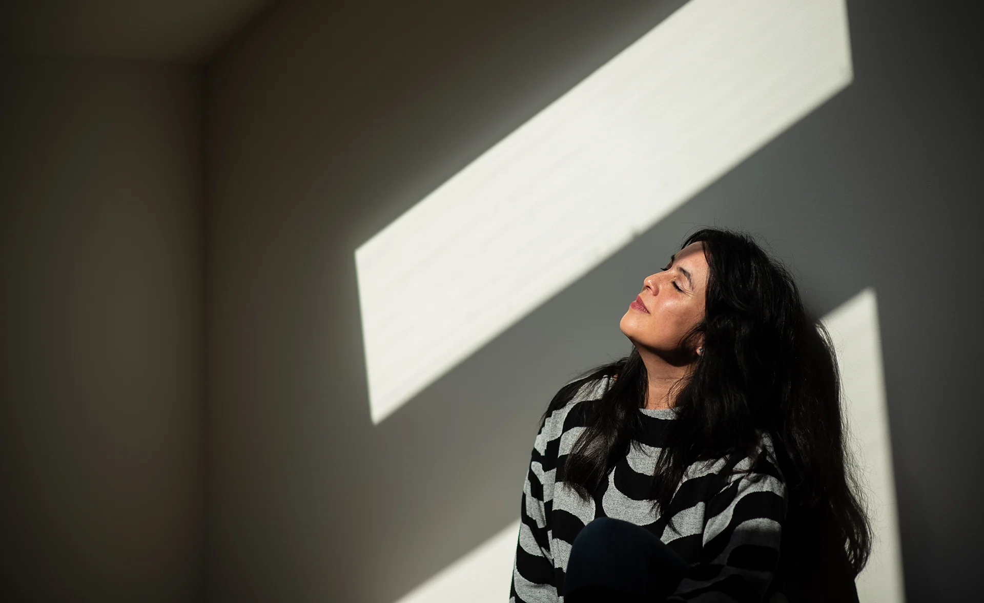 Lena Heinemann Porträtfotografie Stuttgart, Bild einer Frau, die mit geschlossenen Augen an der Wand lehnt