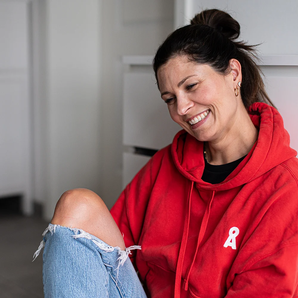 Lena Heinemann Porträtfotografie Stuttgart, Bild einer Frau in einem roten Pullover, lachend