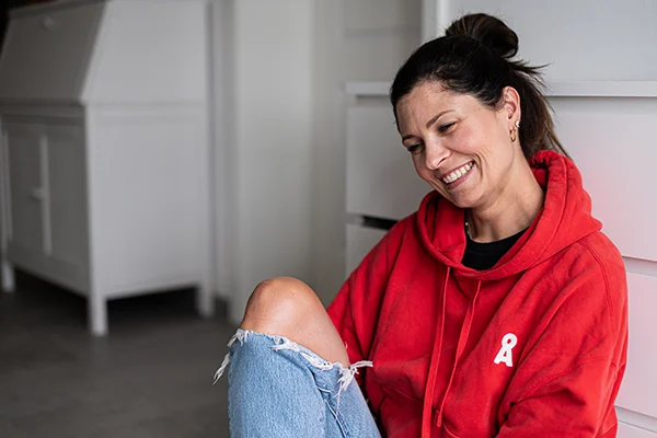 Lena Heinemann Porträtfotografie Stuttgart, Bild einer Frau in einem roten Pullover, lachend